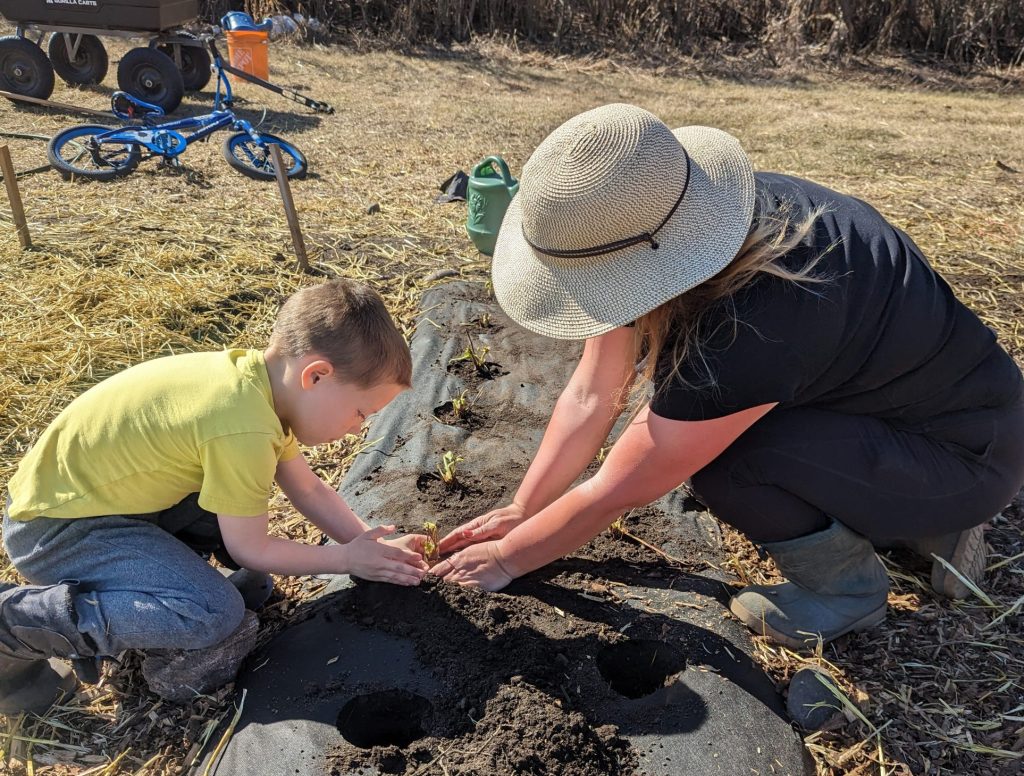 Stacey Audley planting on the farm with her son.