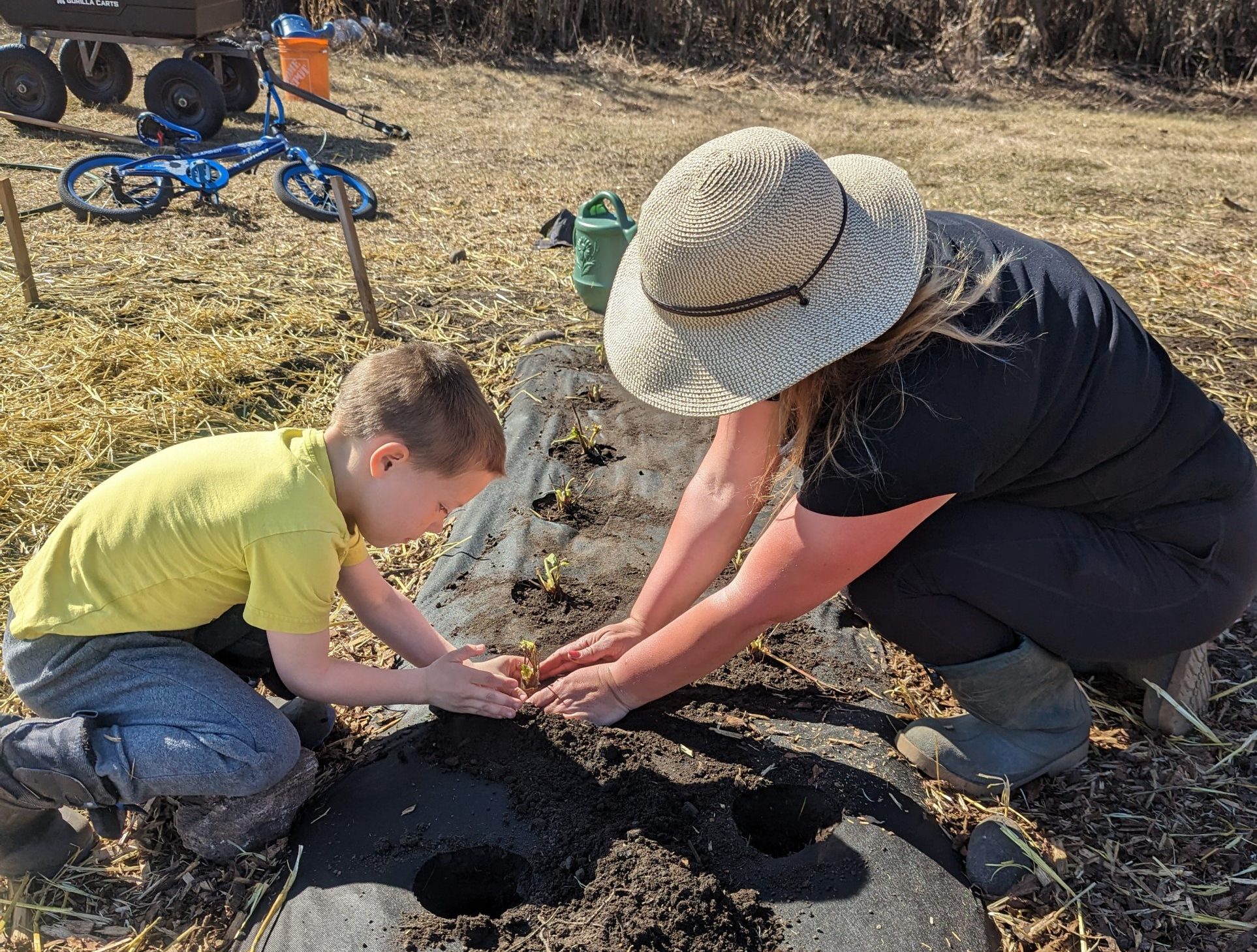 Stacey Audley planting on the farm with her son.